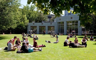 Groups of students sitting on a green space outside a university building. Source: University of Canterbury.