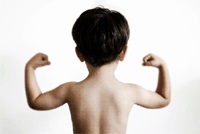 Young boy flexes his muscles to show how strong he is - shown from the back.